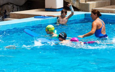 Varna, Bulgaristan - 31 Mayıs 2017: Büyüleyici mutlu çocuk çocuk yüzme havuzu ile banyo keyfini çıkarın. Koç yüzme havuzu çocuklarda öğretir. Spor çocuklar. Çocuk spor