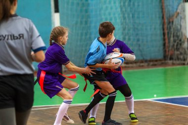 Odessa, Ukrayna - Hazi 24,2018: Küçük çocuklar kapalı salonunda şehir okulun derby Oyunlar sırasında rugby oynamak. Çocuk spor. Çocuk rugby 5 oyun. Çocuk zafer için mücadele. Sağlıklı yaşam tarzı