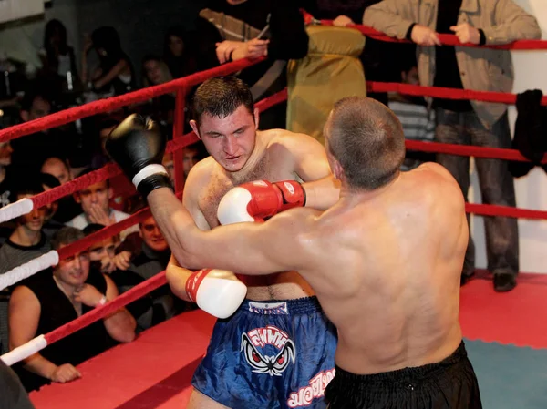 Odessa, Ukraine - October 14, 2010: Fight Club. Fighting without rules. Mixed martial arts fighters compete in the cell, resulting in punches and kicks. The dramatic moment of the battle.