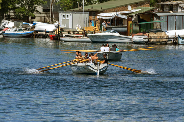 VARNA, BULGARIA - CIRCA 2017: Young athletes train in a rowing team on marine lifeboats in the water area of the port of Varna