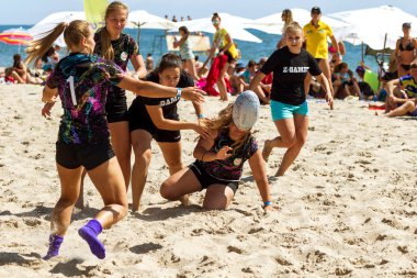 Odessa, Ukrayna - 27 Ağustos 2017: Uluslararası Rugby Festivali kum deniz Beach Zatoka Z-Oyunlar Spor ve müzik festivali sırasında üzerinde. Rugby oyuncuları erkekler ve kadınlar sahil kumu eylem içinde