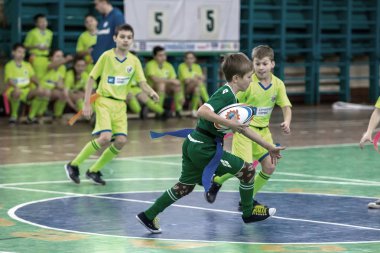 Odessa, Ukrayna - Hazi 24,2018: Küçük çocuklar kapalı salonunda şehir okulun derby Oyunlar sırasında rugby oynamak. Çocuk spor. Çocuk rugby 5 oyun. Çocuk zafer için mücadele. Sağlıklı yaşam tarzı