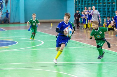 Odessa, Ukrayna - Hazi 24,2018: Küçük çocuklar kapalı salonunda şehir okulun derby Oyunlar sırasında rugby oynamak. Çocuk spor. Çocuk rugby 5 oyun. Çocuk zafer için mücadele. Sağlıklı yaşam tarzı
