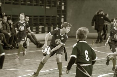 Odessa, Ukrayna - Hazi 24,2018: Küçük çocuklar kapalı salonunda şehir okulun derby Oyunlar sırasında rugby oynamak. Çocuk spor. Çocuk rugby 5 oyun. Çocuk zafer için mücadele. Sağlıklı yaşam tarzı