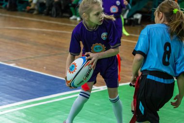 Odessa, Ukrayna - Hazi 24,2018: Küçük çocuklar kapalı salonunda şehir okulun derby Oyunlar sırasında rugby oynamak. Çocuk spor. Çocuk rugby 5 oyun. Çocuk zafer için mücadele. Sağlıklı yaşam tarzı