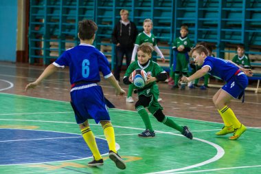 Odessa, Ukrayna - Hazi 24,2018: Küçük çocuklar kapalı salonunda şehir okulun derby Oyunlar sırasında rugby oynamak. Çocuk spor. Çocuk rugby 5 oyun. Çocuk zafer için mücadele. Sağlıklı yaşam tarzı