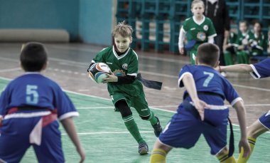 Odessa, Ukrayna - Hazi 24,2018: Küçük çocuklar kapalı salonunda şehir okulun derby Oyunlar sırasında rugby oynamak. Çocuk spor. Çocuk rugby 5 oyun. Çocuk zafer için mücadele. Sağlıklı yaşam tarzı