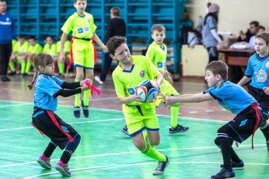 Odessa, Ukrayna - Hazi 24,2018: Küçük çocuklar kapalı salonunda şehir okulun derby Oyunlar sırasında rugby oynamak. Çocuk spor. Çocuk rugby 5 oyun. Çocuk zafer için mücadele. Sağlıklı yaşam tarzı