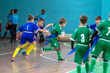 Odessa, Ukrayna - Hazi 24,2018: Küçük çocuklar kapalı salonunda şehir okulun derby Oyunlar sırasında rugby oynamak. Çocuk spor. Çocuk rugby 5 oyun. Çocuk zafer için mücadele. Sağlıklı yaşam tarzı