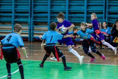 Odessa, Ukrayna - Hazi 24,2018: Küçük çocuklar kapalı salonunda şehir okulun derby Oyunlar sırasında rugby oynamak. Çocuk spor. Çocuk rugby 5 oyun. Çocuk zafer için mücadele. Sağlıklı yaşam tarzı