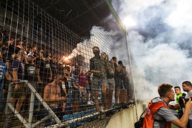 Odessa, Ukrayna-July2, 2018: fanatik hayranları standları ebedi rakip oyun sırasında. Raflar taraftarlara mutlu, yangın ve dalgalanan bayrak ile kızdırma. Ateşli gösteri Stadyumu'nda. Holigan hafif ateşli flashe hayranları