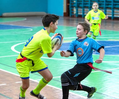 Odessa, Ukrayna - Hazi 24,2018: Küçük çocuklar kapalı salonunda şehir okulun derby Oyunlar sırasında rugby oynamak. Çocuk spor. Çocuk rugby 5 oyun. Çocuk zafer için mücadele. Sağlıklı yaşam tarzı
