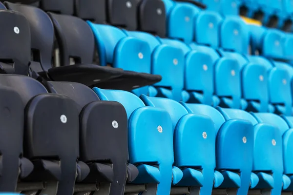 Empty old plastic chairs in the stands of the stadium. Many empty seats for spectators in the stands. Empty plastic chairs, seats for football fans. Tribune, game without spectators