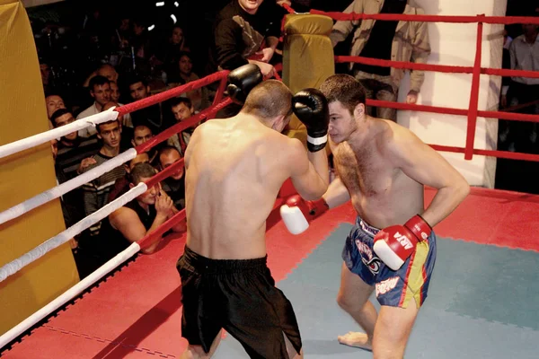 Odessa, Ukraine - October 14, 2010: Fight Club. Fighting without rules. Mixed martial arts fighters compete in the cell, resulting in punches and kicks. The dramatic moment of the battle.