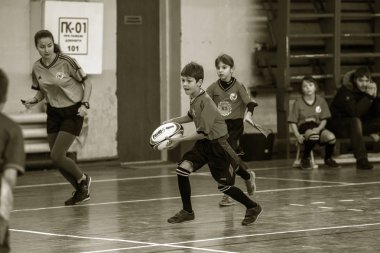 Odessa, Ukrayna - Hazi 24,2018: Küçük çocuklar kapalı salonunda şehir okulun derby Oyunlar sırasında rugby oynamak. Çocuk spor. Çocuk rugby 5 oyun. Çocuk zafer için mücadele. Sağlıklı yaşam tarzı