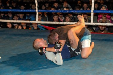 Odessa, Ukrayna - 14 Ekim 2015: Bölgesel kavgalar içinde belgili tanımlık çalmak. Atletizm Mma savaşçıları yarışmak, atar ve yumruk ve tekme ile sonuçlanan dövüş sanatları karışık. Savaşın dramatik an