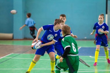 Odessa, Ukrayna - Hazi 24,2018: Küçük çocuklar kapalı salonunda şehir okulun derby Oyunlar sırasında rugby oynamak. Çocuk spor. Çocuk rugby 5 oyun. Çocuk zafer için mücadele. Sağlıklı yaşam tarzı