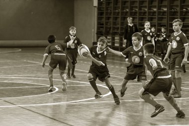 Odessa, Ukrayna - Hazi 24,2018: Küçük çocuklar kapalı salonunda şehir okulun derby Oyunlar sırasında rugby oynamak. Çocuk spor. Çocuk rugby 5 oyun. Çocuk zafer için mücadele. Sağlıklı yaşam tarzı