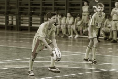 Odessa, Ukrayna - Hazi 24,2018: Küçük çocuklar kapalı salonunda şehir okulun derby Oyunlar sırasında rugby oynamak. Çocuk spor. Çocuk rugby 5 oyun. Çocuk zafer için mücadele. Sağlıklı yaşam tarzı