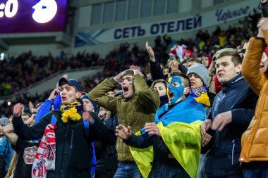 Odessa, Ukrayna - 24 Mart 2016: Futbol taraftarları ve seyirci stadyum standları duygusal onların Ukrayna ve Kıbrıs Milli takım maç sırasında destek ekibi. Duygular, el fenerleri, duman, çığlıkları
