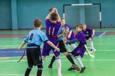 Odessa, Ukrayna - Hazi 24,2018: Küçük çocuklar kapalı salonunda şehir okulun derby Oyunlar sırasında rugby oynamak. Çocuk spor. Çocuk rugby 5 oyun. Çocuk zafer için mücadele. Sağlıklı yaşam tarzı