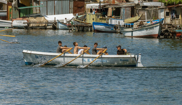 VARNA, BULGARIA - CIRCA 2017: Young athletes train in a rowing team on marine lifeboats in the water area of the port of Varna