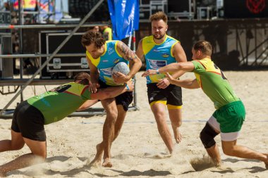 Odessa, Ukrayna - 27 Ağustos 2017: Uluslararası Rugby Festivali kum deniz Beach Zatoka Z-Oyunlar Spor ve müzik festivali sırasında üzerinde. Rugby oyuncuları erkekler ve kadınlar sahil kumu eylem içinde