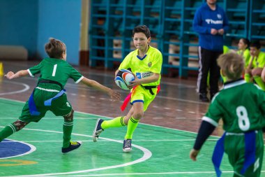 Odessa, Ukrayna - Hazi 24,2018: Küçük çocuklar kapalı salonunda şehir okulun derby Oyunlar sırasında rugby oynamak. Çocuk spor. Çocuk rugby 5 oyun. Çocuk zafer için mücadele. Sağlıklı yaşam tarzı