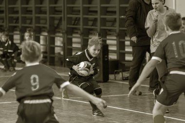 Odessa, Ukrayna - Hazi 24,2018: Küçük çocuklar kapalı salonunda şehir okulun derby Oyunlar sırasında rugby oynamak. Çocuk spor. Çocuk rugby 5 oyun. Çocuk zafer için mücadele. Sağlıklı yaşam tarzı