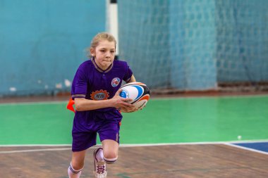 Odessa, Ukrayna - Hazi 24,2018: Küçük çocuklar kapalı salonunda şehir okulun derby Oyunlar sırasında rugby oynamak. Çocuk spor. Çocuk rugby 5 oyun. Çocuk zafer için mücadele. Sağlıklı yaşam tarzı