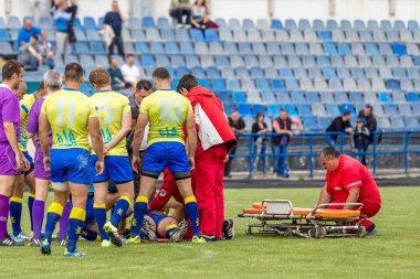 Odessa, Ukrayna - 15 Mayıs 2016: Oyuncu sırasında yarım fincan son rugby Avrupa'nın ciddi bir sakatlık yaşadı. Sert spor oyun tıbbi yardım atlet. Sporcular için ambulans