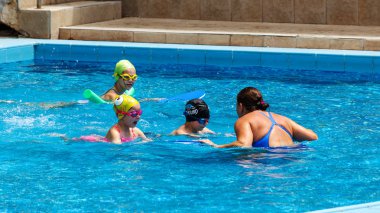 Varna, Bulgaristan - 31 Mayıs 2017: Büyüleyici mutlu çocuk çocuk yüzme havuzu ile banyo keyfini çıkarın. Koç yüzme havuzu çocuklarda öğretir. Spor çocuklar. Çocuk spor