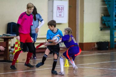 Odessa, Ukrayna - Hazi 24,2018: Küçük çocuklar kapalı salonunda şehir okulun derby Oyunlar sırasında rugby oynamak. Çocuk spor. Çocuk rugby 5 oyun. Çocuk zafer için mücadele. Sağlıklı yaşam tarzı