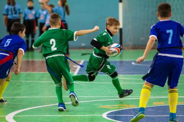Odessa, Ukrayna - Hazi 24,2018: Küçük çocuklar kapalı salonunda şehir okulun derby Oyunlar sırasında rugby oynamak. Çocuk spor. Çocuk rugby 5 oyun. Çocuk zafer için mücadele. Sağlıklı yaşam tarzı