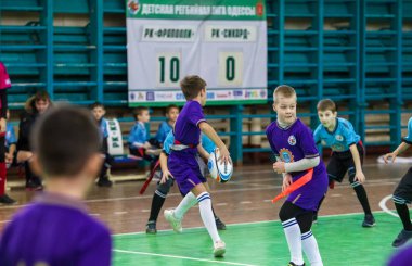 Odessa, Ukrayna - Hazi 24,2018: Küçük çocuklar kapalı salonunda şehir okulun derby Oyunlar sırasında rugby oynamak. Çocuk spor. Çocuk rugby 5 oyun. Çocuk zafer için mücadele. Sağlıklı yaşam tarzı