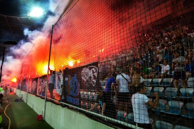 Odessa, Ukrayna-July2, 2018: fanatik hayranları standları ebedi rakip oyun sırasında. Raflar taraftarlara mutlu, yangın ve dalgalanan bayrak ile kızdırma. Ateşli gösteri Stadyumu'nda. Holigan hafif ateşli flashe hayranları