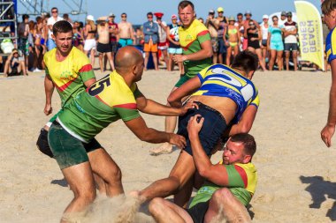 Odessa, Ukrayna - 27 Ağustos 2017: Uluslararası Rugby Festivali kum deniz Beach Zatoka Z-Oyunlar Spor ve müzik festivali sırasında üzerinde. Rugby oyuncuları erkekler ve kadınlar sahil kumu eylem içinde
