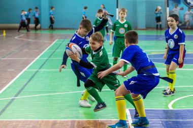 Odessa, Ukrayna - Hazi 24,2018: Küçük çocuklar kapalı salonunda şehir okulun derby Oyunlar sırasında rugby oynamak. Çocuk spor. Çocuk rugby 5 oyun. Çocuk zafer için mücadele. Sağlıklı yaşam tarzı