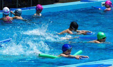 Varna, Bulgaristan - 31 Mayıs 2017: Büyüleyici mutlu çocuk çocuk yüzme havuzu ile banyo keyfini çıkarın. Koç yüzme havuzu çocuklarda öğretir. Spor çocuklar. Çocuk spor