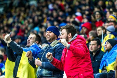 Odessa, Ukrayna - 24 Mart 2016: Futbol taraftarları ve seyirci stadyum standları duygusal onların Ukrayna ve Kıbrıs Milli takım maç sırasında destek ekibi. Duygular, el fenerleri, duman, çığlıkları