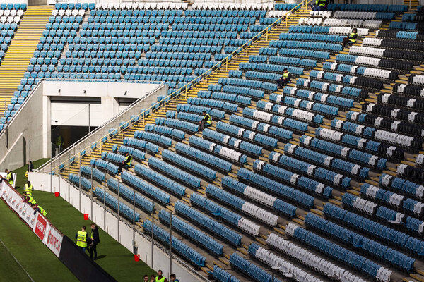 ODESSA, UKRAINE 17.03.2018: Empty old plastic chairs in stands of stadium. Many empty seats for spectators in stands. Empty plastic chairs, seats for football fans. Tribune, game without spectators