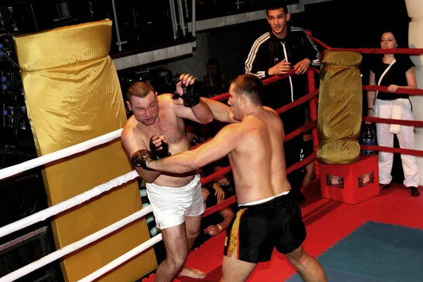 Odessa, Ukraine - October 14, 2010: Fight Club. Fighting without rules. Mixed martial arts fighters compete in the cell, resulting in punches and kicks. The dramatic moment of the battle.