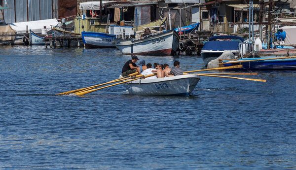 VARNA, BULGARIA - CIRCA 2017: Young athletes train in a rowing team on marine lifeboats in the water area of the port of Varna