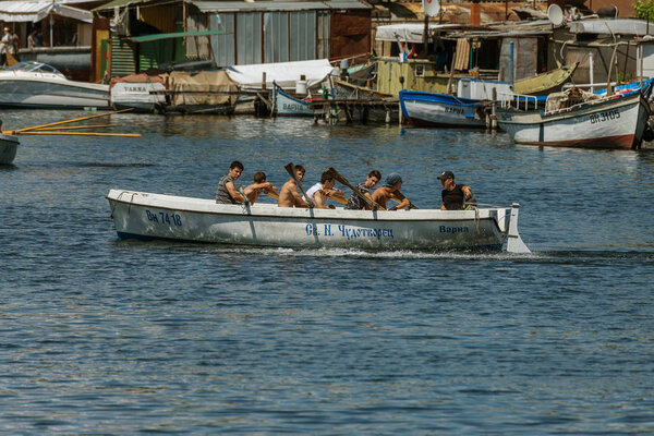 VARNA, BULGARIA - CIRCA 2017: Young athletes train in a rowing team on marine lifeboats in the water area of the port of Varna