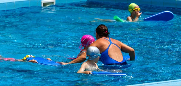 ヴァルナ ブルガリア 2017 魅力的な幸せな子供は 子供のスイミング プールと入浴をお楽しみください コーチは プールの水泳の子供たちを教えています スポーツ子供 子供のスポーツ — ストック写真