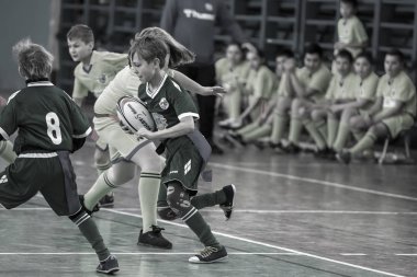 Odessa, Ukrayna - Hazi 24,2018: Küçük çocuklar kapalı salonunda şehir okulun derby Oyunlar sırasında rugby oynamak. Çocuk spor. Çocuk rugby 5 oyun. Çocuk zafer için mücadele. Sağlıklı yaşam tarzı