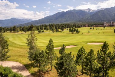 Razlık, Bulgaristan - 29 Temmuz 2016: Pirin Dağı sayısı Todorka ve Vihren en üstündeki. Güzel görünüm yeşil yaz golf sahası. Resort Razlık, Bulgaristan