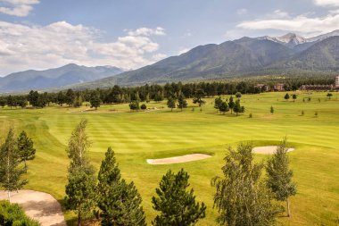 Razlık, Bulgaristan - 29 Temmuz 2016: Pirin Dağı sayısı Todorka ve Vihren en üstündeki. Güzel görünüm yeşil yaz golf sahası. Resort Razlık, Bulgaristan