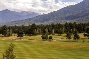 Razlık, Bulgaristan - 29 Temmuz 2016: Pirin Dağı sayısı Todorka ve Vihren en üstündeki. Güzel görünüm yeşil yaz golf sahası. Resort Razlık, Bulgaristan