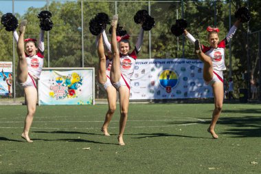 Odessa, Ukrayna - 2 Eylül 2015: Parlak dinamik özellikleri bir destek grubu Bayan spor takımı. Performans destek grubu. Parlak güzel genç kız spor dans formu parkta